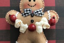 a gingerbread man with a buffalo check bow, a cranberry and popcorn garland is a lovely decoration or ornament for Christmas