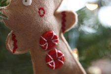 a half eaten felt Christmas ornament with red buttons and embroidery is a pretty and fun decoration for the holidays