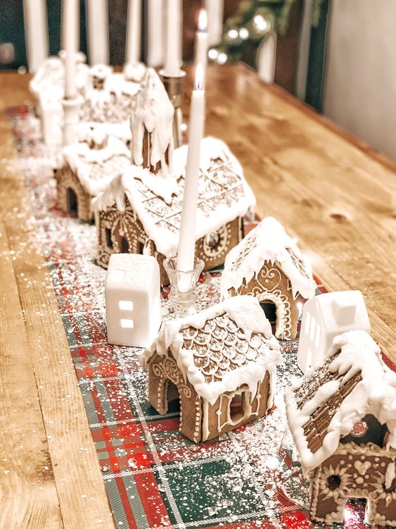 a table runner of gingerbread houses with glazing and candles is a lovely idea for Christmas and for holidays