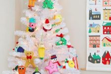 a white Christmas tree with lights and funny colorful ornaments is an easy and fun way to add a holiday feel to the room