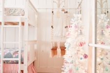 a white Christmas tree with pastel ornaments and lights is all you need to create a holiday atmosphere in the space