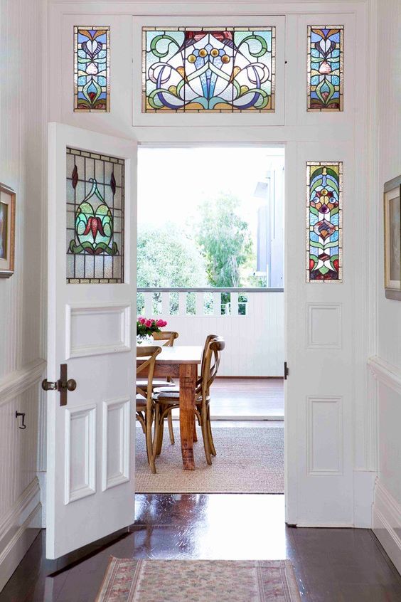 an inner door with sidelights, all of them done with colorful stained glass, adds chic and interest to the space