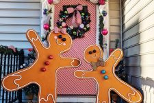 giant gingerbread men with colorful touches make the porch bright and fun and can be DIYed for outdoor Christmas decor