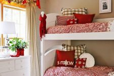 printed red and white bedding, a garland with bows, a scarf and decorative red vase with some greenery for a holiday touch
