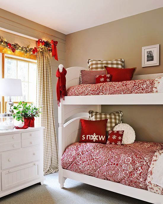 printed red and white bedding, a garland with bows, a scarf and decorative red vase with some greenery for a holiday touch