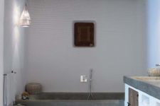 a chic bathroom with white walls, a concrete bathtub, a wooden ceiling and beams and a concrete vanity