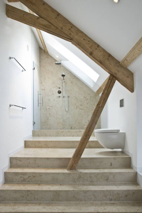 a contemporary attic bathroom with wooden beams, a neutral shower space and warm tiles on the floor