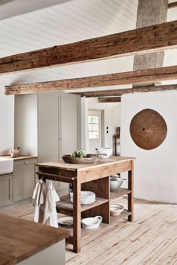 a contemporary neutral kitchen in white and dove grey, a wooden kitchen island, wooden beams for a welcoming feel