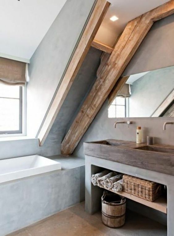 a modern bathroom done with concrete, with wooden beams, a concrete vanity and a wooden sink plus a window
