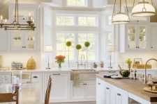 a neutral modern farmhouse kitchen with light-colored wooden beams, wooden chairs and countertops that soften the look