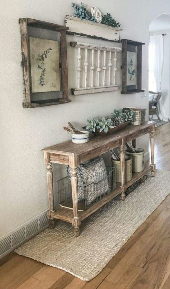 a vintage meets farmhouse entryway with a wooden console, vintage posters as artworks and some jute integrated