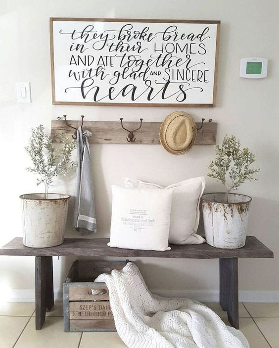 a weathered wooden bench, a crate for storage, some potted plants in buckets, a rack and a sign