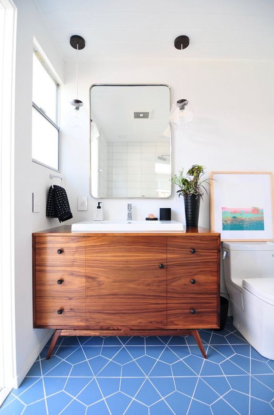 https://www.digsdigs.com/photos/2016/02/a-bright-mid-century-modern-bathroom-with-blue-geo-tiles-on-the-floor-a-rich-stained-vanity-and-touches-of-black-for-accenting.jpg