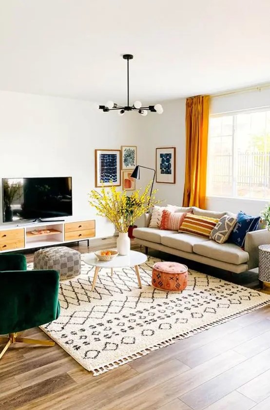 a bright mid-century modern living room with a comfy sofa, a green chair, a TV unit, printed textiles and a bright gallery wall