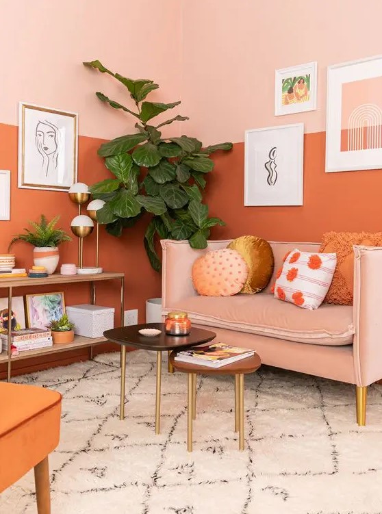 a gorgeous warm-toned living room with color block walls, a blush sofa and an orange chair plus cool artworks