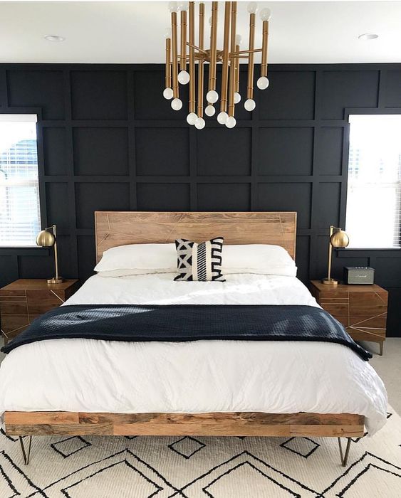 a mid-century modern meets Scandinavian bedroom with wooden furniture, a brass chandelier and brass lamps