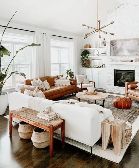 a welcoming mid-century modern living room with a built-in fireplace, a white and rust-colored sofa, a woven bench, potted plants