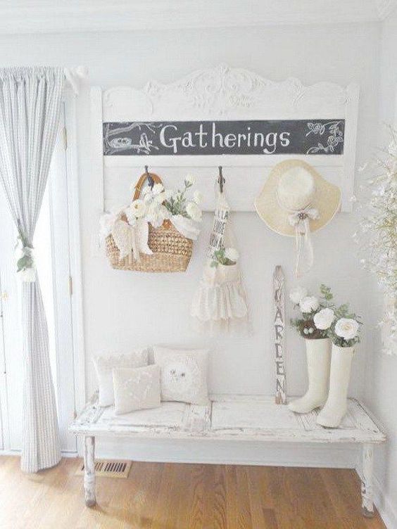 a white shabby chic entryway with a chic chalkboard sign, a whitewashed bench, blue curtains and baskets
