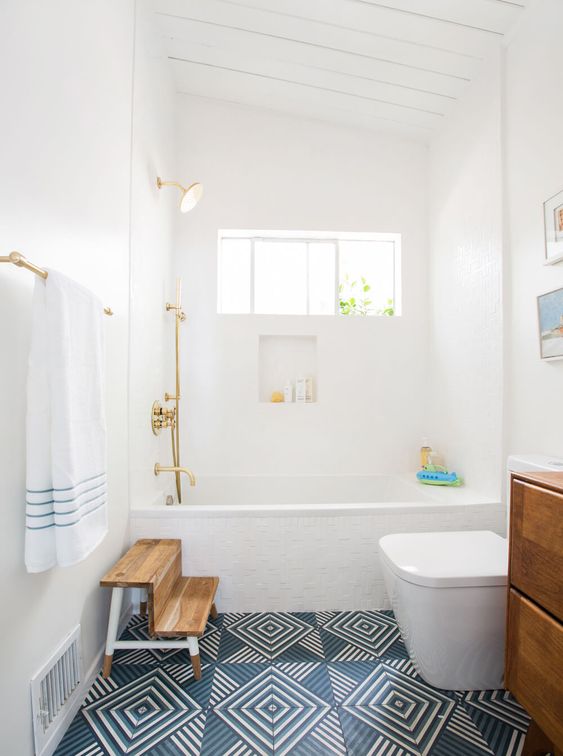 an airy mid-century modern space with blue printed tiles, a gallery wall, wooden furniture and touches of gold