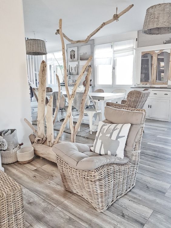 a coastal space with neutral wicker chairs, baskets for storage, a piece of wood with whitewashed branches, wicker lampshades