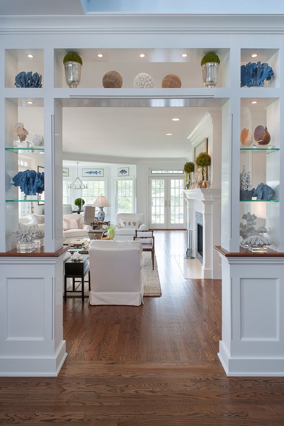 a doorway open storage unit with usual and glass shelves, with built-in lights is a cool idea to store and separate the spaces