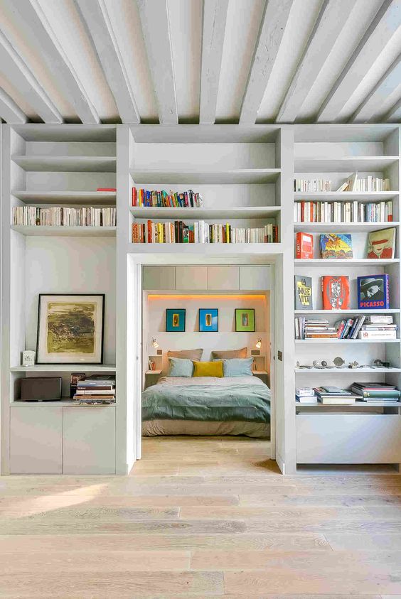 a doorway surrounded with open shelves used for storing books and artworks is a very cool idea to go for