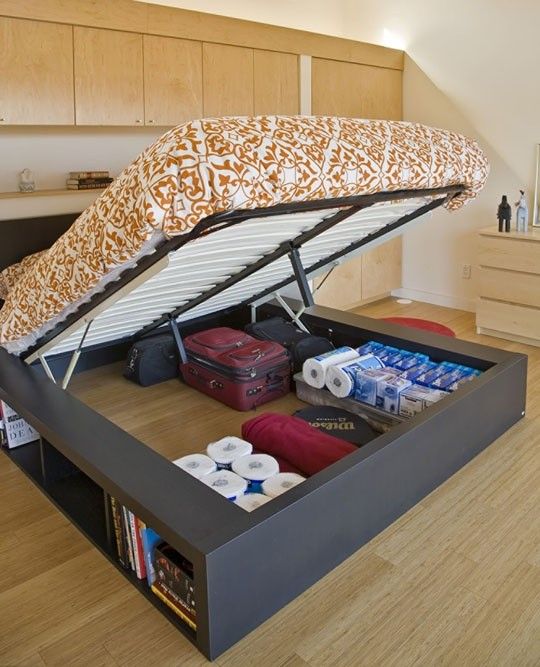a large storage bed with a lot of things stored inside and open storage compartments is very cool