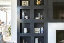 a modern living room featuring a fireplace and a series of niche shelves for displaying various decor