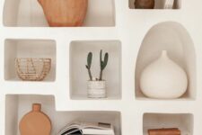 a neutral wall with a series of niche shelves is a great way to display various decor and accessories