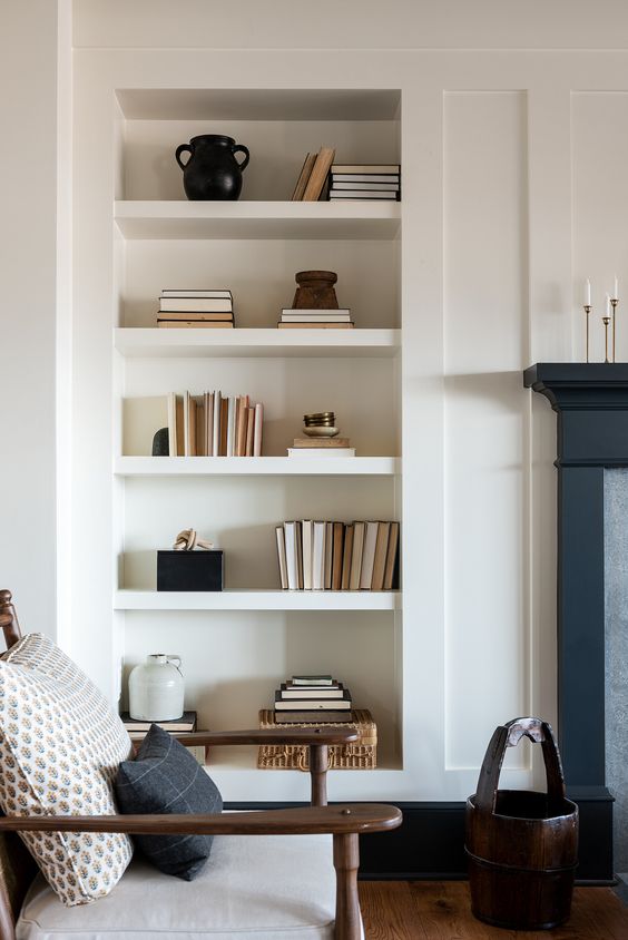 a niche with a series of shelves is a stylish idea for any space, here it's used to display books and vases of various kinds