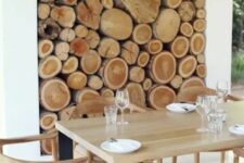 a niche with firewood as a decor feature for an outdoor dining room, to connect it to nature and make it look cozy