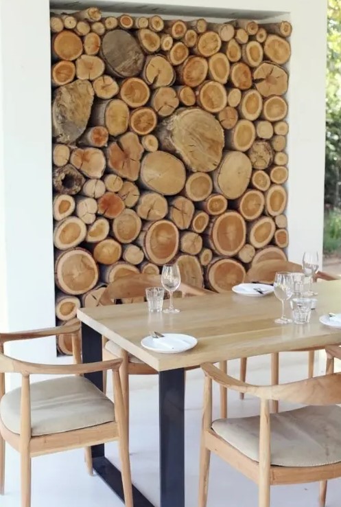 a niche with firewood as a decor feature for an outdoor dining room, to connect it to nature and make it look cozy