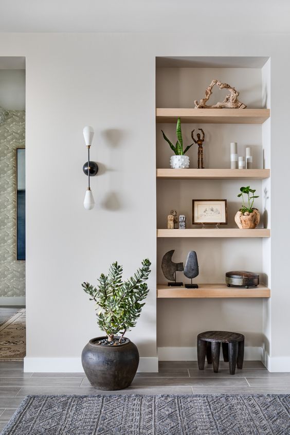 a niche with multiple wooden shelves is a great way to make use of an awkward nook you have