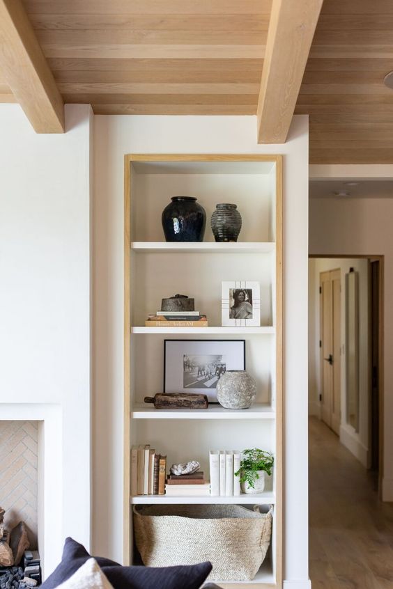 a niche with shelves lined up with stained wood is a stylish idea for a living room, here you can display anything you want