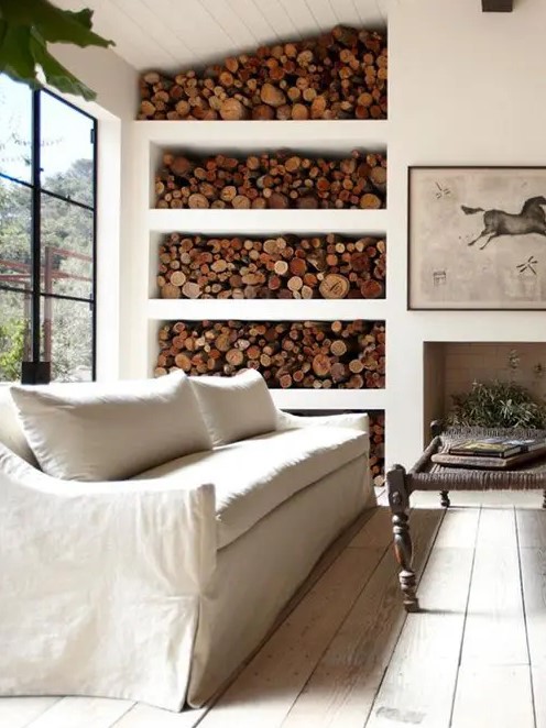 a non-working fireplace and an open storage unit with firewood make this Provence room cozy and welcoming