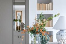 a series of sleek wall niches is used as a bookcase, which is a smart idea to save floor space and not to add more furniture here