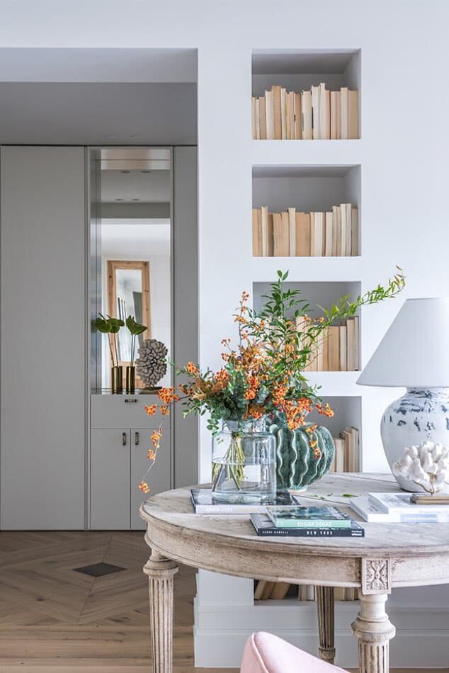 a series of sleek wall niches is used as a bookcase, which is a smart idea to save floor space and not to add more furniture here