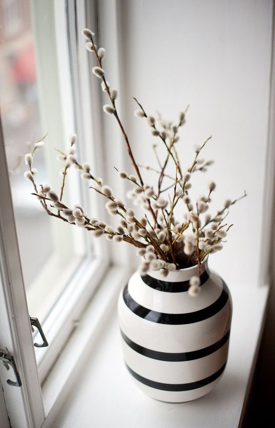 a striped black and white vase with willow is a lovely spring decoration in Nordic style