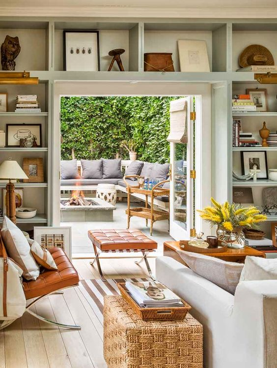 a welcoming neutral living room with open shelves over the doorway for displaying things, books and other stuff is a cool idea to save some space