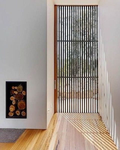 a wood slab window screen lets light in but keeps the space absolutely private and comfortable