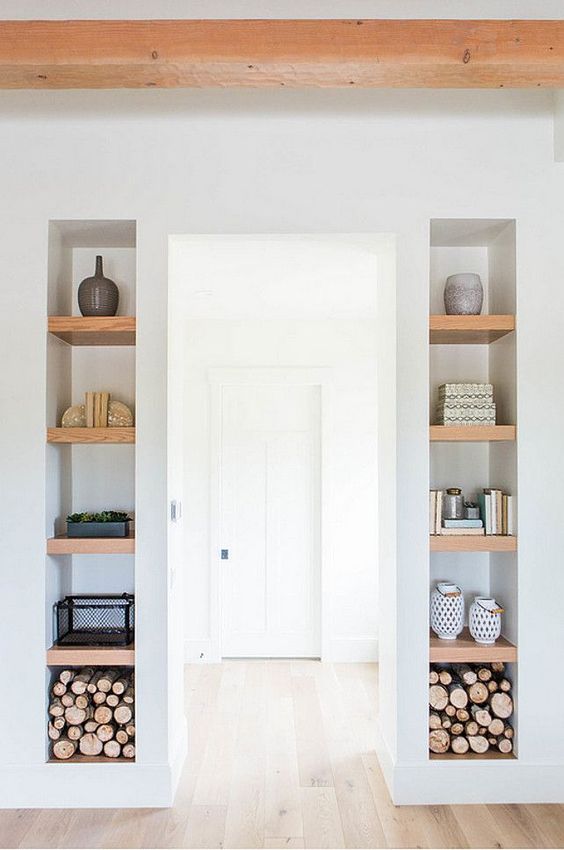 long and narrow niches with wooden shelves inside add decorative value to the space and show off some stuff inside