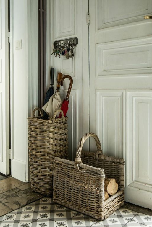 wicker baskets, one used for umbrellas, and another for storing firewood are great to style your entryway with a rustic feel