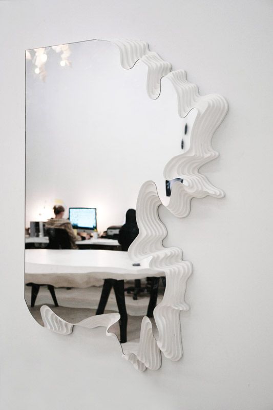 a beautifully shaped mirror with en edge that resembles a puzzle piece is a unique idea for a modern space, such partial framing will be great