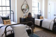 a bold shared boy bedroom with metal beds, a black sideboard, a plaid ottoman and cool star lamps