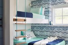 a bright seaside-inspired shared boy bedroom with an accent wall, a bunk bed, a ladder and bright bedding