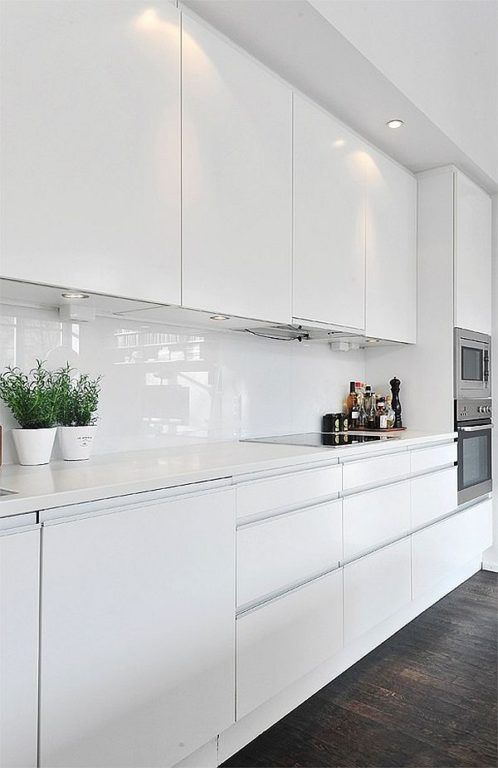 يعد المطبخ الأبيض الناصع مع باكسبلاش الزجاجي الأبيض وأسطح العمل الحجرية فكرة رائعة للمساحة الاسكندنافية