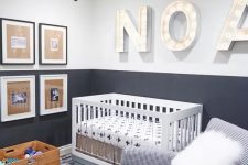 a contemporary grey and white nursery with a faceted pendant lamp, marquee letters, a mini gallery wall, a white wood and clear acrylic crib, a printed chair