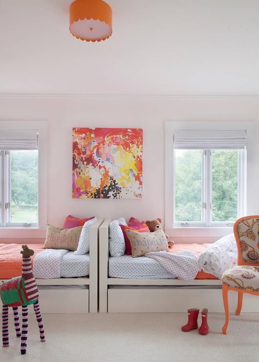 a cool and bold shared girls' bedroom with white beds, a bright chair, a colorful artwork and bedding, an orange pendant lamp and a toy a cool and bold shared girls' bedroom with white beds, a bright chair, a colorful artwork and bedding, an orange pendant lamp and a toy