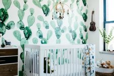 a desert-themed nursery with a watercolor cactus wall, a reclaimed wood dresser is a cool and bright space