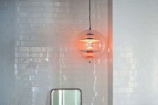 a large pendant lamp of clear glass and metallic touches will accent any bathroom makign it more eye-catchy